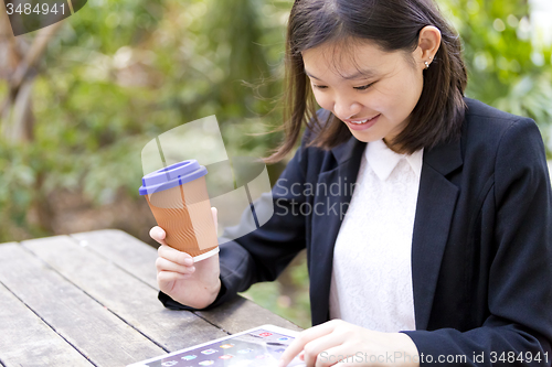 Image of Young Asian female business executive using tablet