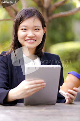 Image of Young Asian female business executive using tablet