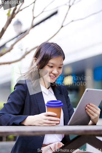 Image of Young Asian female business executive using tablet