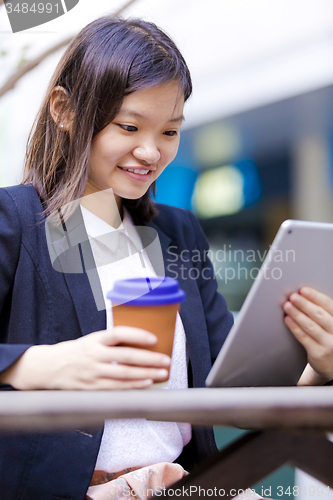 Image of Young Asian female business executive using tablet