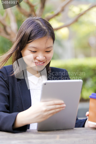 Image of Young Asian female business executive using tablet