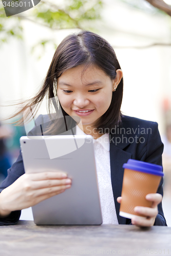 Image of Young Asian female business executive using tablet