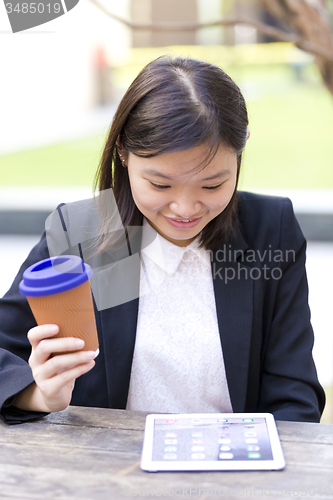 Image of Young Asian female business executive using tablet