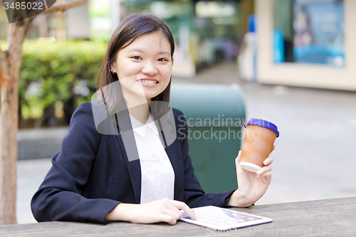Image of Young Asian female business executive using tablet