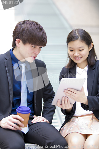 Image of Young Asian female and male business executive using table