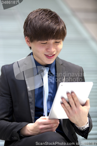Image of Young Asian male business executive using table