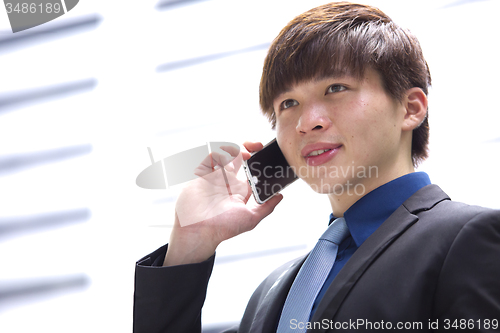 Image of Young Asian male business executive using smart phone