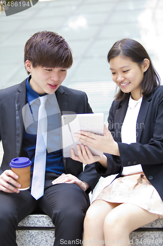 Image of Young Asian female and male business executive using table