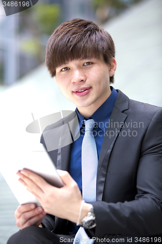 Image of Young Asian male business executive using tablet