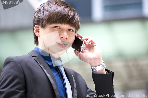 Image of Young Asian male business executive using smart phone