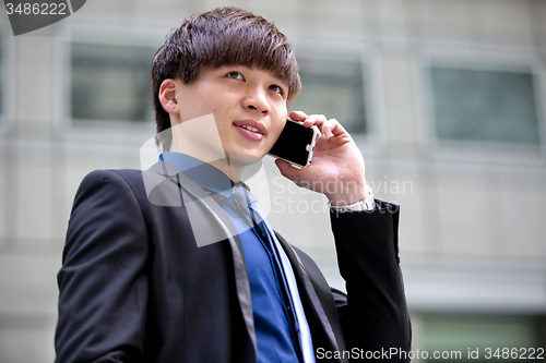 Image of Young Asian male business executive using smart phone