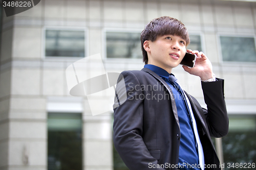 Image of Young Asian male business executive using smart phone