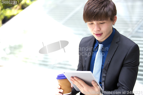 Image of Young Asian male business executive using tablet