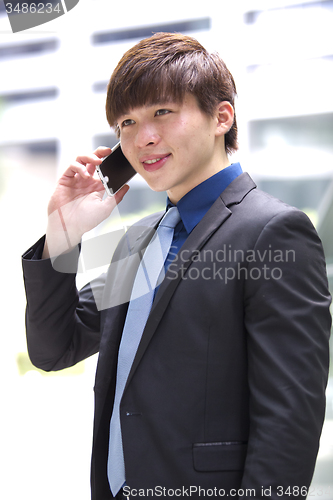 Image of Young Asian male business executive using smart phone