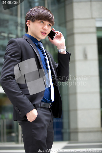 Image of Young Asian male business executive using smart phone