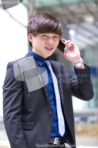 Image of Young Asian male business executive using smart phone