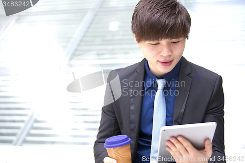 Image of Young Asian male business executive using tablet