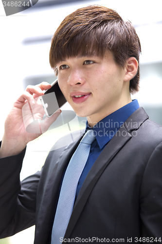Image of Young Asian male business executive using smart phone