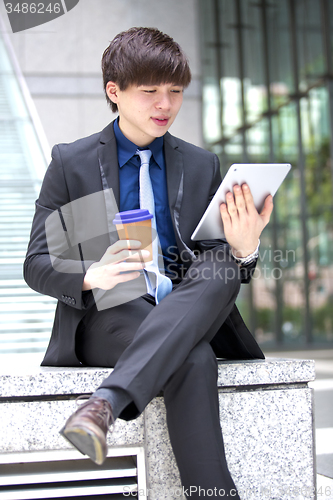 Image of Young Asian male business executive using tablet