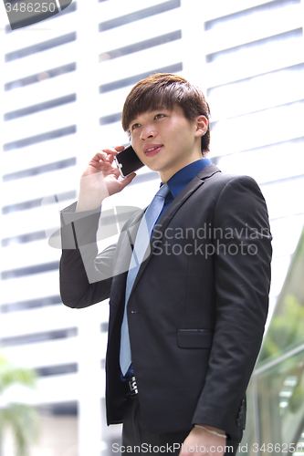 Image of Young Asian male business executive using smart phone