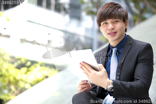 Image of Young Asian male business executive using tablet