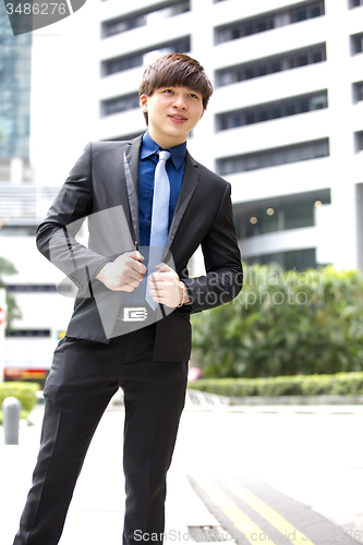 Image of Young Asian business executive in suit smiling portrait