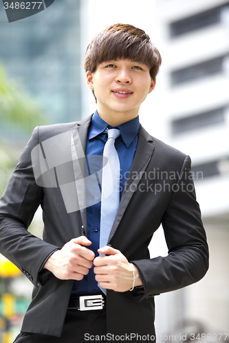 Image of Young Asian business executive in suit smiling portrait