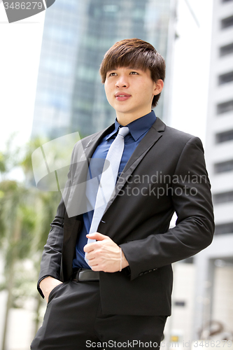 Image of Young Asian business executive in suit smiling portrait