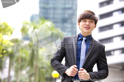 Image of Young Asian business executive in suit smiling portrait