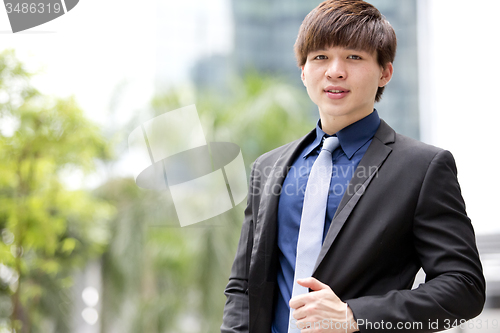 Image of Young Asian business executive in suit smiling portrait