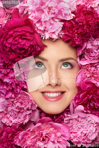 Image of Beautiful girl with pink peony flowers