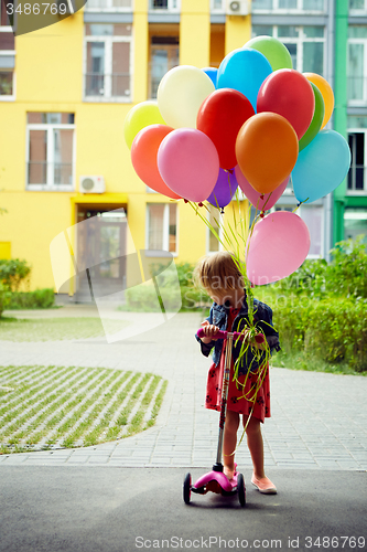 Image of happy little girl outdoors with balloons