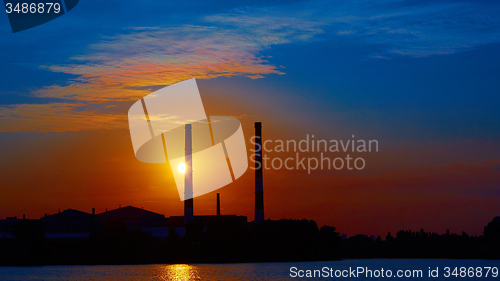 Image of factory in silhouette and sunrise sky