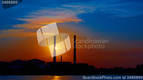 Image of factory in silhouette and sunrise sky