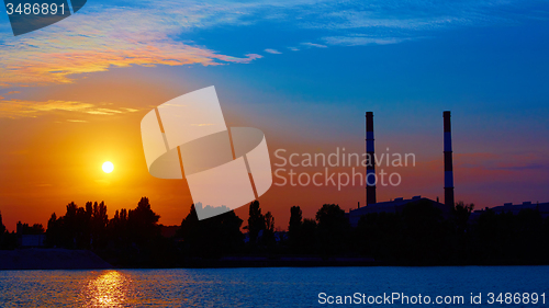 Image of factory in silhouette and sunrise sky