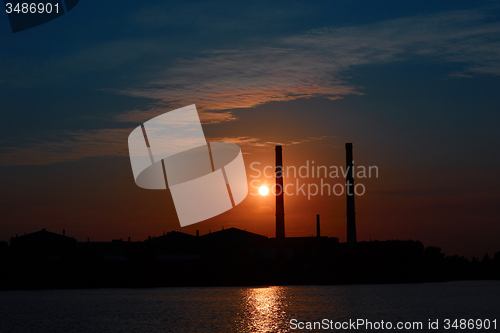 Image of factory in silhouette and sunrise sky