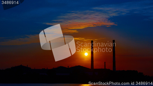 Image of factory in silhouette and sunrise sky