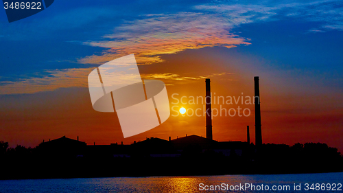 Image of factory in silhouette and sunrise sky