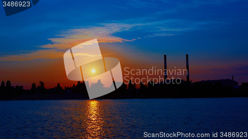 Image of factory in silhouette and sunrise sky