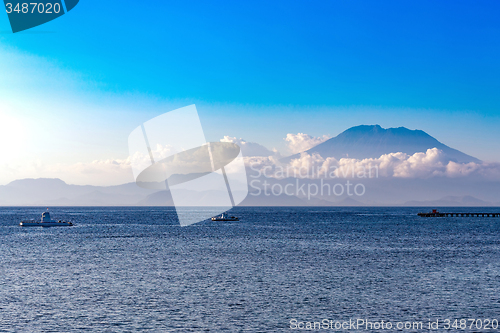 Image of view on Bali from ocean, vulcano in clouds