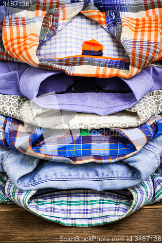 Image of cotton shirts on a wooden shelf in a clothes store