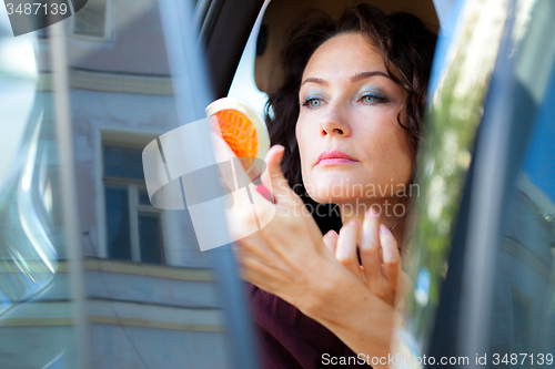 Image of pretty middle-aged woman checked the makeup