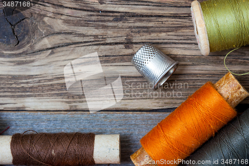 Image of thimble and spools of thread