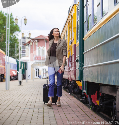 Image of beautiful middle-aged woman with a suitcase