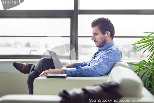 Image of Businessman in office working on laptop computer.