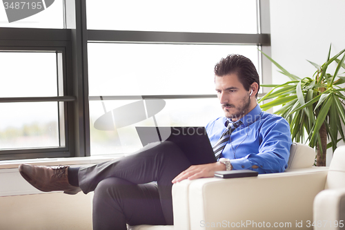 Image of Businessman in office working on laptop computer.