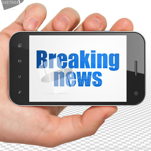 Image of News concept: Hand Holding Smartphone with Breaking News on display