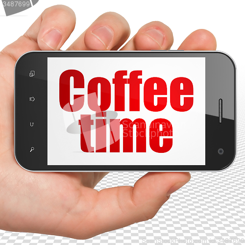 Image of Time concept: Hand Holding Smartphone with Coffee Time on display