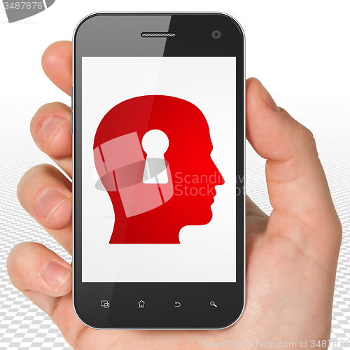 Image of Learning concept: Hand Holding Smartphone with Head With Keyhole on display