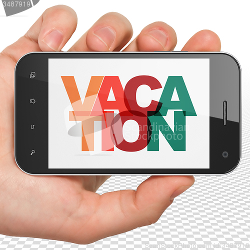 Image of Tourism concept: Hand Holding Smartphone with Vacation on  display